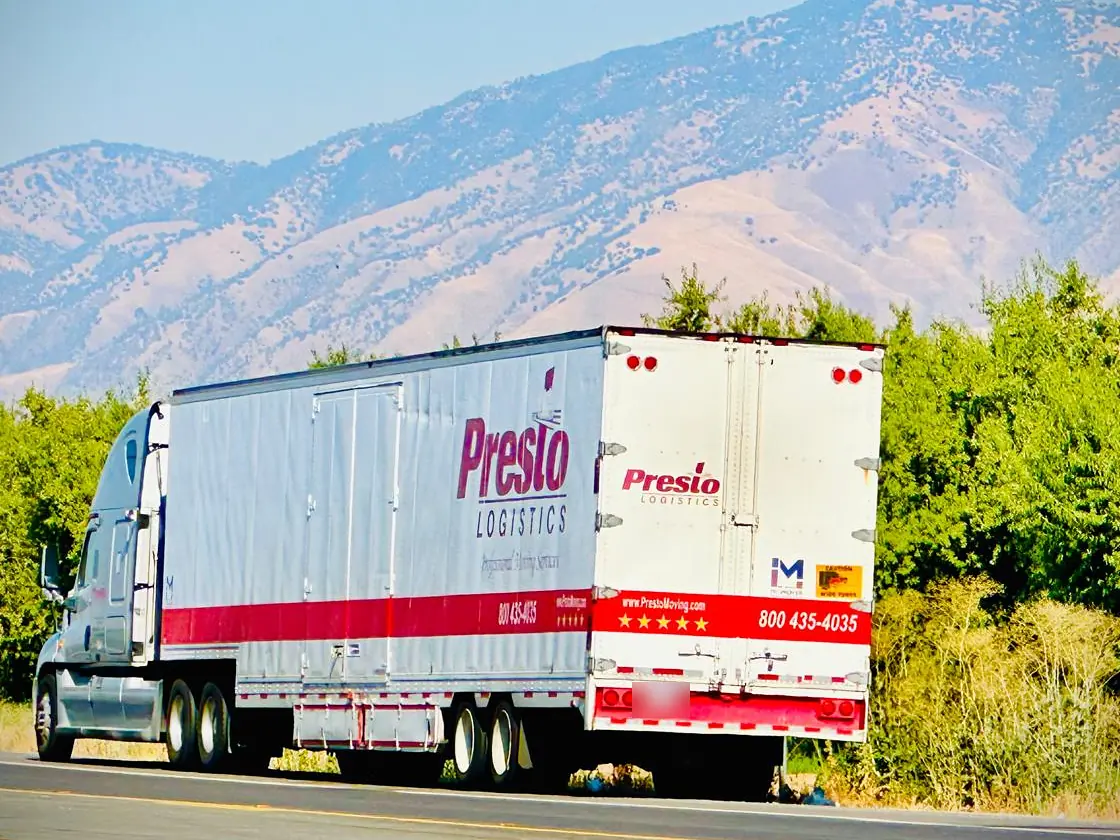 Presto moving truck on the highway with mountains behind