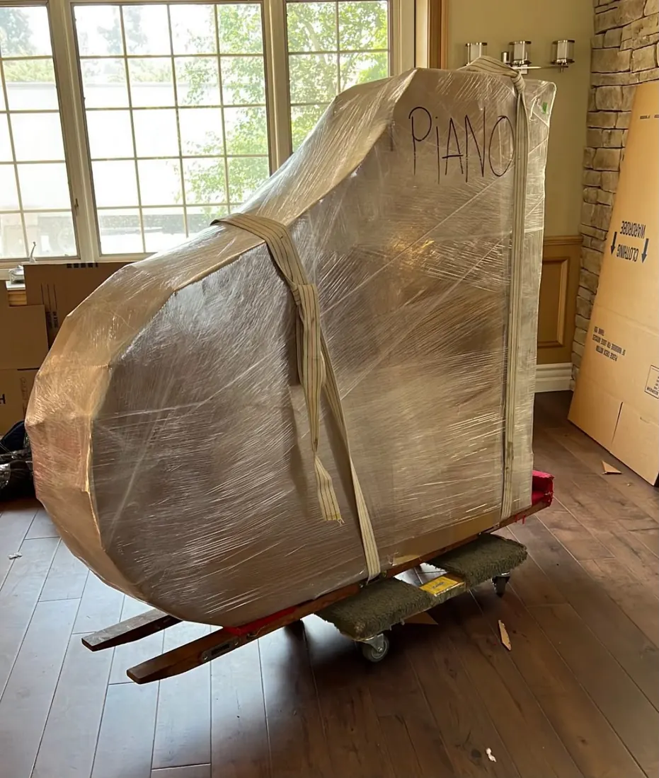 Grand piano padded and strapped to a piano board by Presto movers