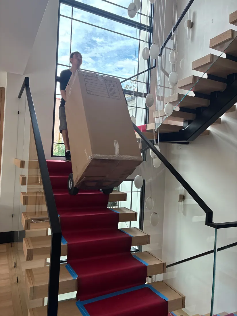 Presto mover carrying a box up the stairs